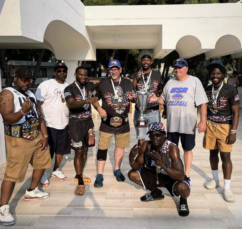 USA Football International team members celebrating with a trophy and medals